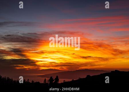 Touristen beobachten den dramatischen Sonnenuntergang hinter den Inseln El Hierro und La Gomera aus einer Höhe von etwa 2000 Metern über dem Meeresspiegel Stockfoto