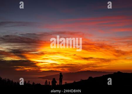 Touristen beobachten den dramatischen Sonnenuntergang hinter den Inseln El Hierro und La Gomera aus einer Höhe von etwa 2000 Metern über dem Meeresspiegel Stockfoto