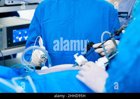 Hände von Chirurgen mit laparoskopischen chirurgischen Geräten. Selektiver Fokus. Operation der Bauchhöhle. Chirurgische Behandlung proktologischer Erkrankungen. Stockfoto