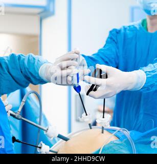 Abdominalchirurgie Operationsprozess mit laparoskopischen Geräten. Selektiver Fokus. Hände von Chirurgen mit chirurgischen Geräten. Chirurgische Behandlung proktologischer Erkrankungen. Stockfoto