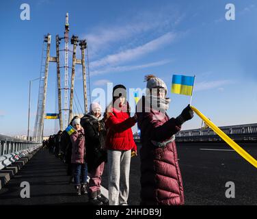 ZAPORIZHZHIA, UKRAINE - 22. JANUAR 2022 - Aktivisten halten am Tag der Einheit während des Blitzes der lebenden Kette blaue und gelbe Fahnen im Rahmen des Starts Stockfoto