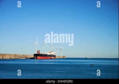 Der Öltanker, der am Öltankerterminal im Hafen von Bilbao angedockt ist, und Windturbinen im Hintergrund, Zierbena, Biscay, Baskenland, Euskadi, Sp Stockfoto