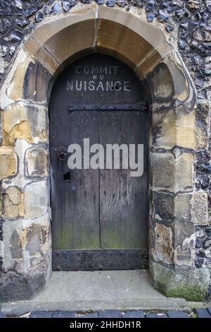 Kleine Holztür mit dem Schild Commit No Ärgernis auf dem alten Uhrenturm, St Albans, Hertfordshire, Großbritannien Stockfoto