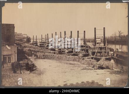 [Supply Steamers in Nashville, Tennessee] 1862 Rodney Poole American die scheinbar endlose Reihe von Dampfschiffen entlang der Anlegestelle in Nashville, Tennessee, Liefert einen genauen Bericht über die komplexen Vorbereitungen, die erforderlich sind, um die US-Armee vor einem bevorstehenden Bürgerkrieg zu versorgen – in diesem Fall die Schlacht von Murfreesboro am 28. Dezember 1862. Die quadratischen Behälter im Vordergrund sind eindeutig als „Pilotbrot der US-amerikanischen Bäckerei Evansville, Ind.“ gekennzeichnet. Dieser getrocknete Keks, der gewöhnlich als Hardtack bekannt ist, war eine übliche Vorschrift, mit der Soldaten oder öfter Hunger hatten Stockfoto