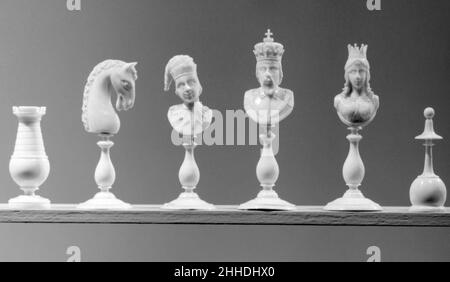 Schachfiguren (32) ca. 1870–80 French, Dieppe die Formen der Stücke sind auf beiden Seiten identisch, mit Ausnahme der Könige und Königinnen. Die Verarbeitung der Saatkrähen und Bauern ist besonders gut. Die Bischöfe, wie es in französischen Sätzen üblich ist, sind "fous" (Idioten oder Narren), tragen Narrenkappe und gelbtem Kragen. Der weiße König kann gemeint sein, um König Ferdinand von Spanien zu repräsentieren, was die Theorie unterstützen würde, dass dieses Set die Rückeroberung Spaniens von den Mauren darstellt und für den spanischen Markt bestimmt war. Schachfiguren (32). Französisch, Dieppe. Ca. 1870–80. Elfenbein, Ebenholz. Schachsätze Stockfoto