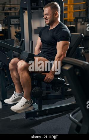 Männlicher Athlet, der an Fitnessgeräten arbeitet Stockfoto