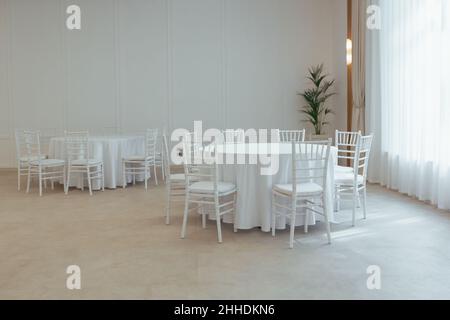 Weiße runde Tische mit einer Tischdecke, um im Restaurant Teil des Dekors und der Innenausstattung zu feiern Stockfoto