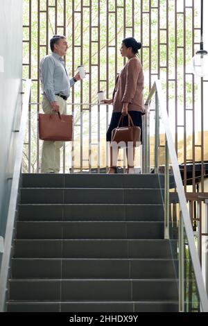 Geschäftsleute stehen auf Stufen und diskutieren über die Arbeit, die sie tun müssen Stockfoto