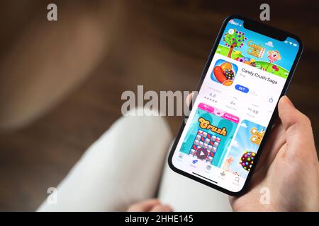 Charkow, Ukraine - 19. Januar 2022: Candy Crush Saga Spiel-App. Mädchen hält Handy mit Spiel und wollen spielen. Beliebtes Konzept für mobile Spiele Stockfoto