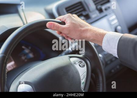 Nahaufnahme eines Geschäftsmannes, der das Lenkrad des Autos hält Stockfoto