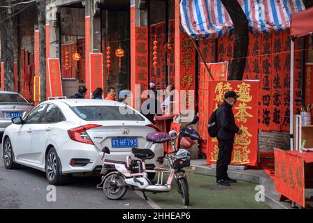 Foshan, Provinz Guangdong, China. JANUAR 14, 2022. Menschen, die Couplets mit Grüßen für das Frühlingsfest schreiben. Vorbereitung auf das chinesische Neujahr Stockfoto