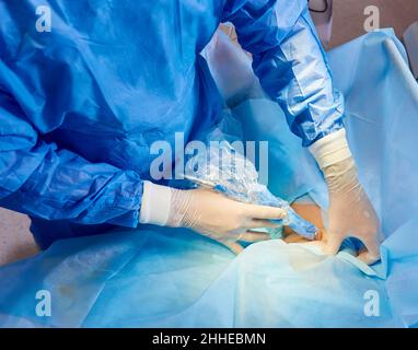 Im Operationssaal des Krankenhauses Diverse Team von professionellen Chirurgen und Krankenschwestern Naht Wunde nach erfolgreicher Operation. Stockfoto