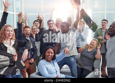 Glückliche multiethnische Mitarbeiter, die einen Sieg feiern Stockfoto