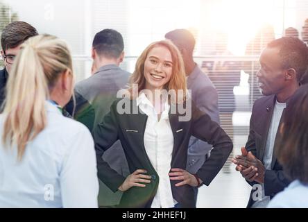 Ein glückliches, vielfältiges professionelles Business-Team steht im Büro und schaut sich an Kamera Stockfoto