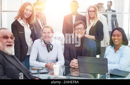 Multinationale Arbeitsgruppe, die am Büroschalter sitzt. Stockfoto