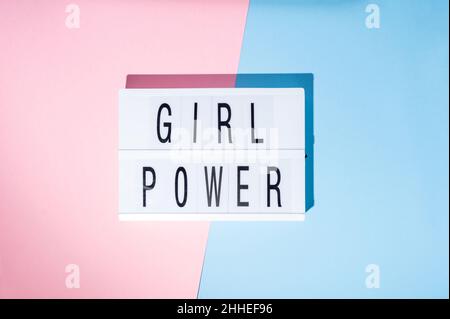 Girl Power-Text auf dem Leuchtkasten. Draufsicht auf ein Konzept des Feminismus mit einem rosa und blauen Hintergrund Stockfoto