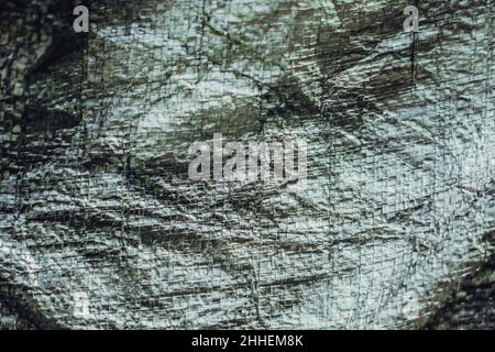 Abstrakt realen Stoff Oberfläche Hintergrund. Aluminium Platinum Silver Folie Tarpaulin Effekt mit rauer Textur Grapfkante. Futurism 80s Retro-Stil neu Stockfoto