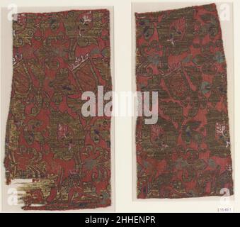 Textilfragmente 15th. Jahrhundert Diese rechteckigen roten Seidentextilien, die einst miteinander verbunden wurden, sind mit Blumenmustern, Blättern, heraldischen Schilden und gekrönten Löwen verziert und mit goldfarbenen Fäden verziert. Mudejar-Handwerker freuten sich an den Granatapfel-, Palmette- und Lotusmotiven und verwendeten sie oft in Kombination mit Tieren oder Vögeln. Lange horizontale Linien von Blumen biegen sich in eine Richtung und in eine andere, was die Illusion von Blüten in einer Brise schwanken lässt. Weitere dekorative Elemente in diesen Fragmenten sind Reihen von gekrönten Löwen sowie krönte Schilde, die sich bewegen Stockfoto