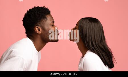 Seitenansicht des küssenden afroamerikanischen Millennials-Paares Stockfoto