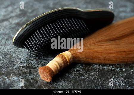 Eine Haarsträhne mit weiblichem Haar und Haarbürste, Nahaufnahme Stockfoto