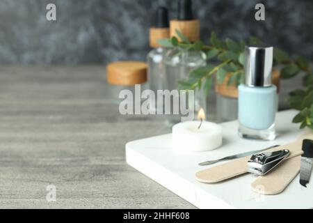 Konzept der Nagelpflege mit Maniküre-Accessoires auf grauem Holztisch Stockfoto
