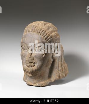 Tuffkopf der Sphinx oder Sirene ca. 550–525 v. Chr. Etrusker, wahrscheinlich Vulkangestein dieser große Kopf aus vulkanischem Stein stellt wahrscheinlich eine Sphinx oder Sirene dar. Statuen beider Fabelwesen, die gewöhnlich von den Alten mit menschlichen weiblichen Köpfen und geflügelten Tier- oder Vogelkörpern dargestellt werden, wurden oft als Wächter in der Nähe der Eingänge zu etruskischen Gräbern aufgestellt. Der große geflügelte Löwe, der in dieser Galerie ausgestellt ist, ist ein besser erhaltenes Beispiel für diese Art von Steinskulptur. Der Stil dieses weiblichen Kopfes mit seinen mandelförmigen Augen, seinem archaischen Lächeln und seiner perückenähnlichen Haaranordnung erinnert stark an Griechisch, Stockfoto