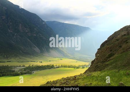 Alpines grünes Tal des Flusses Chulyshman im AK-Kurum-Trakt mit riesigen Bergen und Sonnenlicht im Sommer Stockfoto