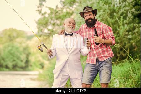 Prost. Männer entspannende Natur Hintergrund. Spaß und Entspannung. Am Wochenende. Angelkenntnisse. Die Stange mit der Hakenlinse aufsetzen. Angeln und Bier trinken Stockfoto