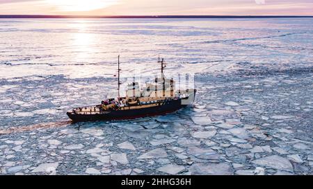 Eisbrecher geht auf dem Meer zwischen dem blauen Eis bei Sonnenuntergang, Luftaufnahme Stockfoto