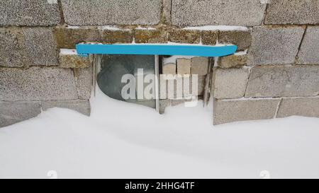 Ziegel und Ziegel vom Busfenster an der Vorderwand mit Schnee Stockfoto