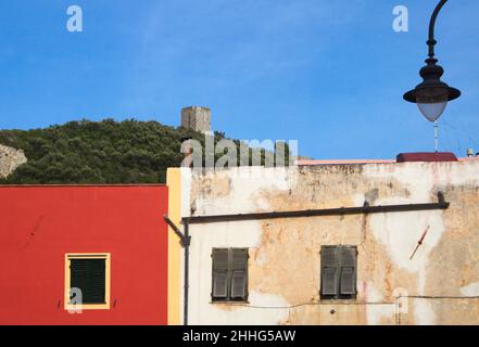 Häuser in Varigotti und der Sarazenenturm in Punta Crena im Hintergrund, Ligurien, Italien Stockfoto