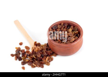 Rosinen in einem Löffel. Rosinen in einer Schale isoliert auf weißem Hintergrund. Stockfoto