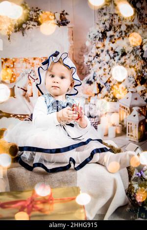 Baby Dressed sitzt in der Nähe von Weihnachten Stockfoto