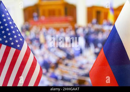Die US-Flagge und die russische Flagge vor dem Hintergrund vieler Menschen. Flagge der USA, Flagge Russlands. Die Vereinigten Staaten von Amerika und die Russische Föderation Stockfoto