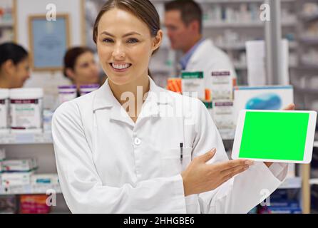 Apotheker von heute. Porträt eines attraktiven Apothekers, der ein leeres digitales Tablet-Display hochhält. Stockfoto