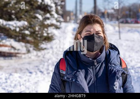 Hispanische Frau, die nach einem starken Schneefall in der Stadt Besorgungen durchlief. Lebensstil echter Menschen in der Wintersaison Stockfoto