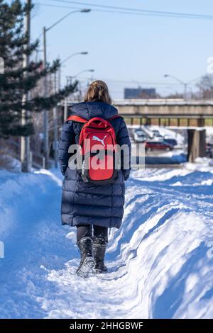 Hispanische Frau, die nach einem starken Schneefall in der Stadt Besorgungen durchlief. Lebensstil echter Menschen in der Wintersaison Stockfoto