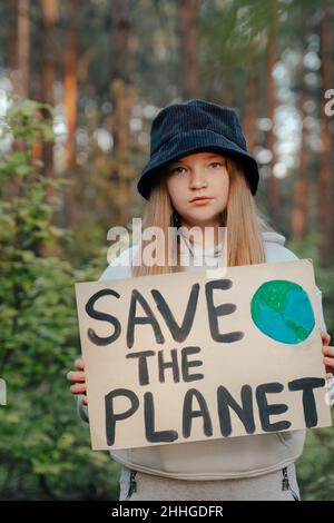 Kind Mädchen Aktivist mit retten den Planeten Poster im Waldpark. Preteen Kind Freiwilligen Kampf gegen Verschmutzung, Globale Erwärmung, Müll zu recyceln. Ecolog Stockfoto