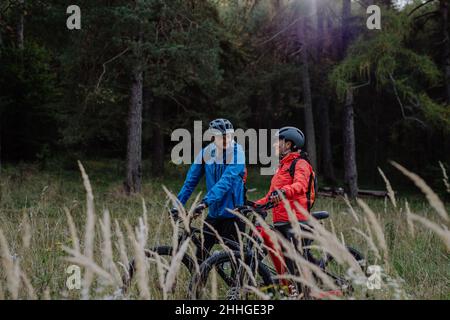 Happy Senior paar Biker umarmen im Freien in der Natur im Herbst Tag. Stockfoto