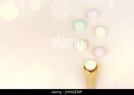 Waffelhorn mit farbigem Moormarmelauch sieht aus wie Makronen auf einem rosa pastellfarbenen Hintergrund. Draufsicht. Freier Speicherplatz für Text Stockfoto