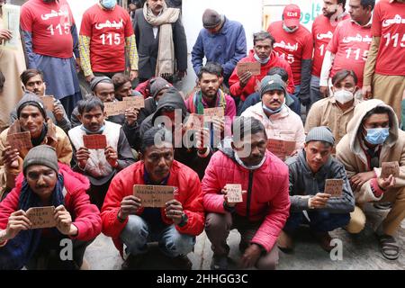 Lahore, Punjab, Pakistan. 24th Januar 2022. Indische Fischer, die aus Karachi kommen, sitzen auf einem Fahrzeug in der Nähe des Edhi-Zentrums und halten Namenskarten für die eingetroffenen Wagha-Grenzen, um nach indien einzureisen, nachdem sie freigelassen wurden, als sie in pakistanischen Hoheitsgewässern in Lahore zum Angeln inhaftiert waren. Pakistan hat am Sonntag 20 indische Fischer entlassen, die inhaftiert wurden, weil sie unrechtmäßig in ihre Hoheitsgewässer eindonnert hatten, teilte das Innenministerium mit. Die Fischer wurden aus einem Gefängnis in der Hafenstadt Karachi entlassen und in die nordöstliche Stadt Lahore gebracht, wo sie an die indischen Behörden der übergeben werden Stockfoto