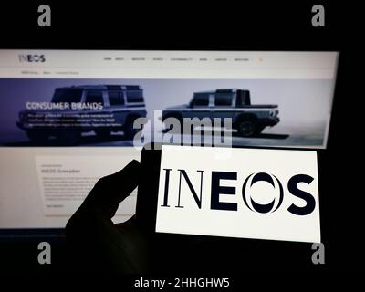 Person, die Mobiltelefon mit dem Logo des britischen Chemieunternehmens INEOS Group Ltd. Auf dem Bildschirm vor der Geschäftswebseite hält. Konzentrieren Sie sich auf die Telefonanzeige. Stockfoto