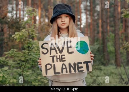 Kind Mädchen Aktivist mit retten den Planeten Poster im Waldpark. Preteen Kind Freiwilligen Kampf gegen Verschmutzung, Globale Erwärmung, Müll zu recyceln. Ecolog Stockfoto