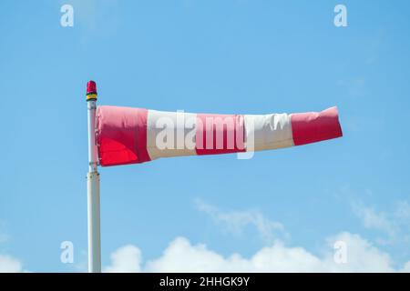 Windsack gegen blauen Himmel und Wolken zeigten die Windrichtung. Stockfoto