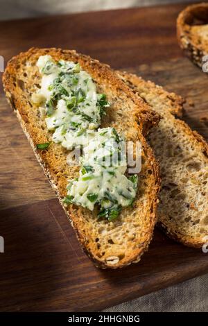 Gesunde hausgemachte Kräuterbutter und Brot mit Rosmarin und Petersilie Stockfoto