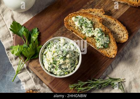 Gesunde hausgemachte Kräuterbutter und Brot mit Rosmarin und Petersilie Stockfoto