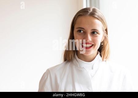 Porträt einer lächelnden jungen Frau im Laborkittel Stockfoto