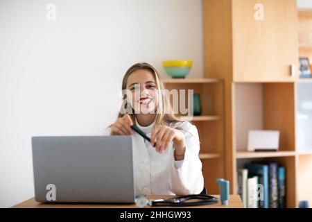 Porträt einer lächelnden jungen Ärztin mit Laptop Stockfoto