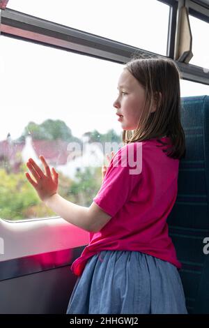 Mädchen Êlooking durch das Fenster im Zug Stockfoto