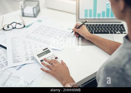 Ihr Geschäft wird geprüft. Nahaufnahme einer unkenntlichen Geschäftsfrau, die in einem Büro die Finanzen berechnet. Stockfoto